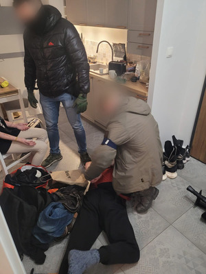 Dwaj policjanci z zatrzymanym mężczyzną i kobietą.