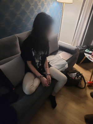 Siedząca na kanapie młoda kobieta.