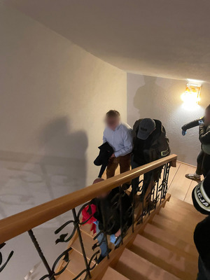 Zatrzymany mężczyzna schodzi po schodach.