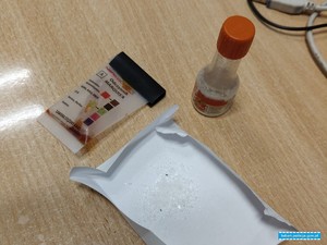 Narkotyki w postaci kryształków na kartce obok pozytywny tester narkotykowy.