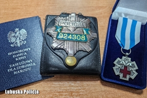 Książeczka, odznaka policyjna i medal.