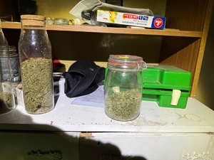 Na biurku stoją słoiki z narkotykami.