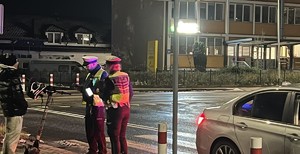 policjanci stoją na chodniku. obok jest nastolatek.