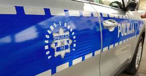 Logo &quot;Pomagamy i chronimy&quot; na bocznej stronie radiowozu.