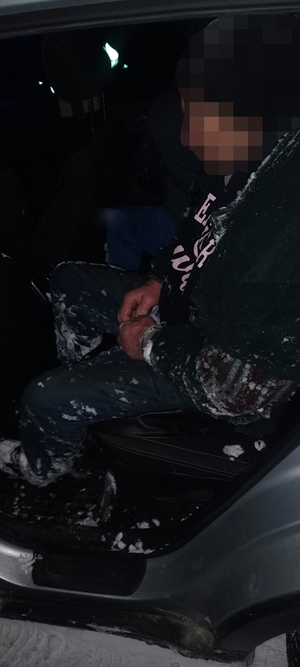 mężczyzna siedzi w radiowozie.