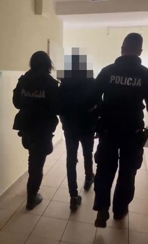 Dwoje policjantów prowadzi zatrzymanego.