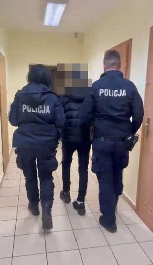 Dwoje policjantów prowadzi zatrzymanego.