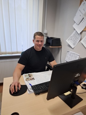 Nieumundurowany policjant przy biurku.