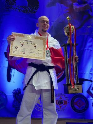 sierż. Oskar Kozieł prezentuje dyplom i puchar zdobyty w zawodach.