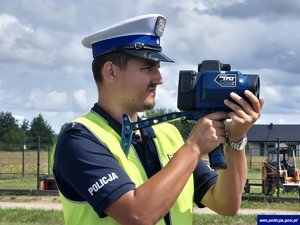 mł. asp. Jakub Wygnał z fotoradarem podczas mierzenia prędkości.
