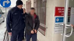 Policjant prowadzi zatrzymanego.