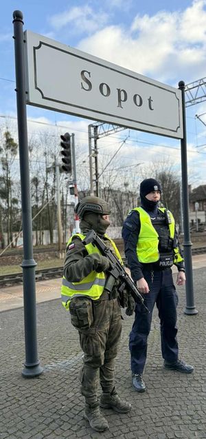 Funkcjonariusz Policji oraz starsza szeregowa z 73. Batalionu Lekkiej Piechoty Wojsk Obrony Terytorialnej stoją na peronie dworca kolejowego w Sopocie.