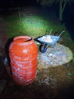 zabezpieczone narkotyki w taczce, obok jest czerwona beczka.