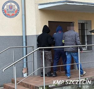 Dwaj policjanci prowadzą zatrzymanego.