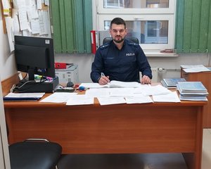 Policjant za biurkiem.
