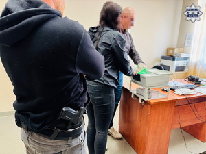 policjanci prowadzą zatrzymaną.