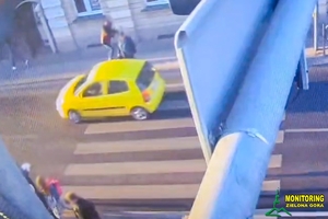 Auto przejeżdżające przez pasy, na których znajduje się człowiek - stop klatka z nagrania z monitoringu.