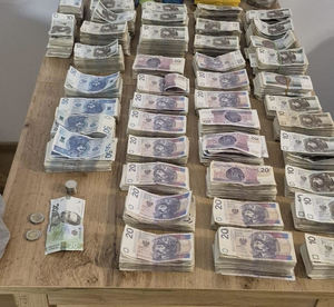 Poukładane na stosach odzyskane banknoty o rożnych nominałach.