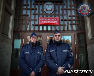Dwóch umundurowanych policjantów pozuje do zdjęcia w drzwiach Komisariatu Policji Szczecin - Niebuszewo.