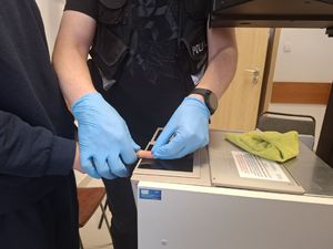 Policjant pobiera odciski palców.