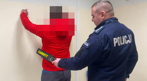 Policjant sprawdza zatrzymanego.