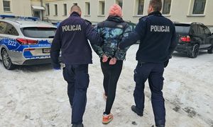 policja prowadzi w kajdankach sprawcę.