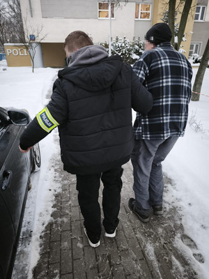 policja prowadzi starszego mężczyznę.