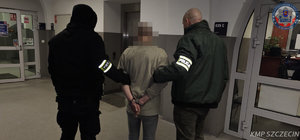 policjanci prowadzą zatrzymanego.