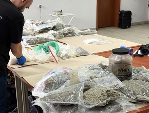 Policjant przy zabezpieczonych narkotykach.