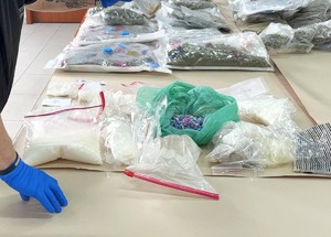 Widoczna dłoń policjanta i zabezpieczone narkotyki.