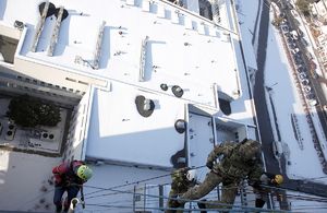 Funkcjonariusze BOA i alpiniści schodzą na linach z dachu szpitala.