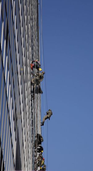 Funkcjonariusze BOA i alpiniści schodzą na linach z dachu szpitala.