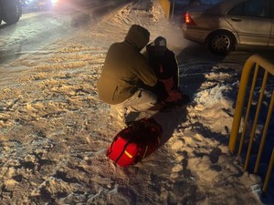 Mężczyzna przy człowieku, który siedzi na śniegu.