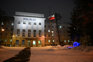 Budynek Komendy Wojewódzkiej Policji w Białymstoku i widoczny zboku podświetlony pomnik.