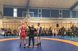 Sędzia z zawodnikami na macie.