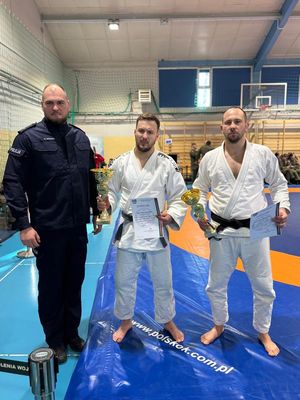 Policjant w mundurze z dwoma judokami.