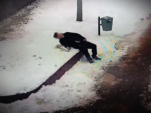 Stopklatka z nagrania monitoringu przedstawia mężczyznę lezącego na śniegu.