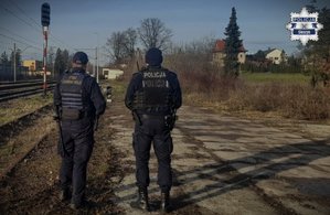 Policjant i Strażnik Ochrony Kolei stoją przy torach - zdjęcie poglądowe.
