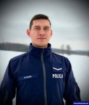 Policjant w mundurze pozuje do zdjęcia.