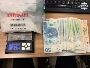 Na zdjęciu biały proszek w worku na wadze, obok banknoty pięćdziesięcio stu i dwustuzłotowe.