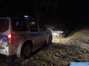 policjant prowadzi zatrzymanego.