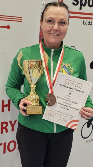 Policjantka z pucharem, dyplomem i medalem na szyi.