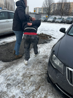 Policjanci prowadzą zatrzymanego.