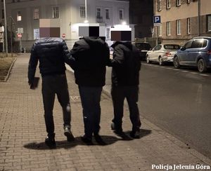Policjanci prowadzą zatrzymanego.