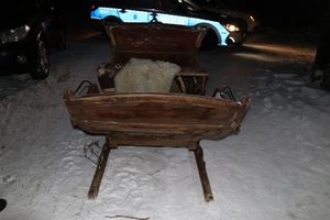 duże sanie konne stoją przed radiowozem.