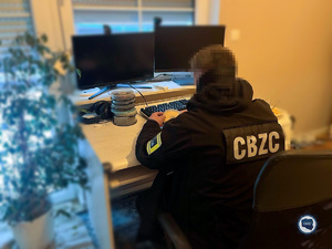 Funkcjonariusz CBZC siedzi przed ekranem komputera.