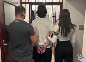 Dwoje nieumundurowanych policjantów prowadzi zatrzymanego.