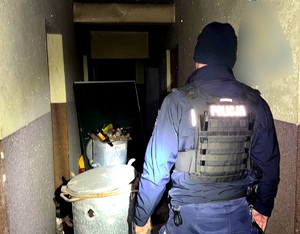 Policjant w pomieszczeniu gdzie przebywał bezdomny.