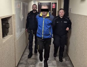 Policjanci prowadzą zatrzymanego.