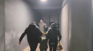 Policjanci prowadzą zatrzymanych.